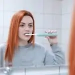 young woman brushing teeth